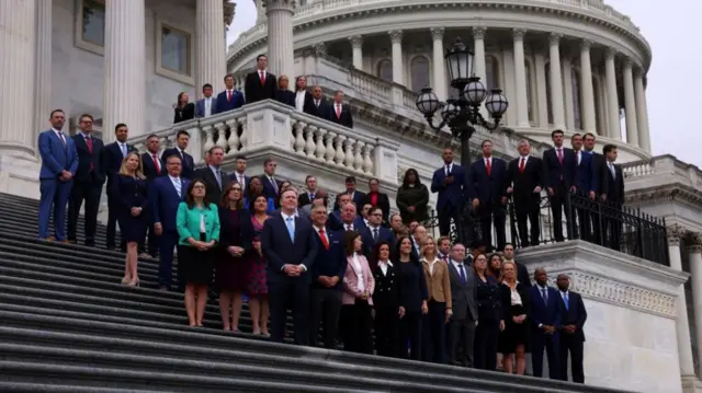 New members of Congress pose for their first picture outside of Capitol Hill, with rotunda dome visible at the top right of the image