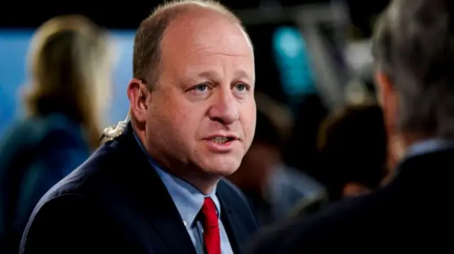 Jared Polis, governor of Colorado, speaks to members of the media in the spin room following the first vice presidential debate at the CBS Broadcast Center