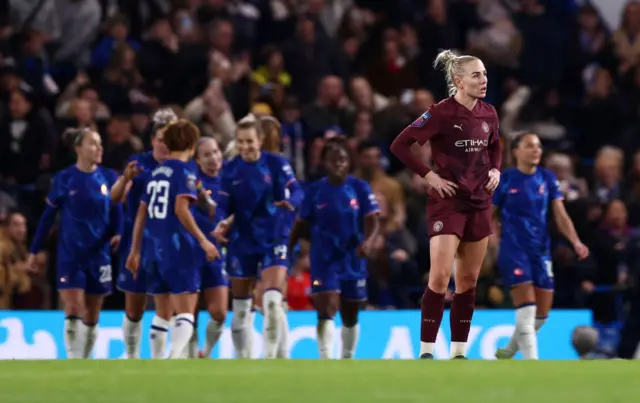 Greenwood stands with her hands on her hips as Chelsea celebrate