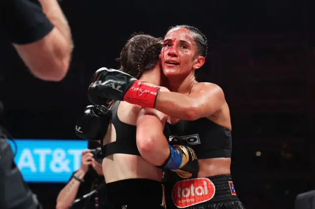 Katie Taylor is hugged by a bloody Amanda Serrano