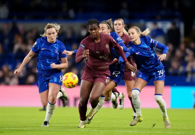 Shaw tries to break away from a group of Chelsea defenders