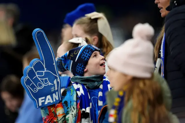 Chelsea fans wave a foam finger in the stands