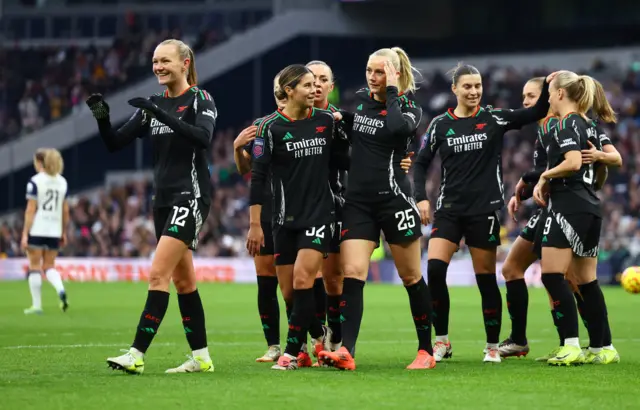 Blackstenius is mobbed by teammates after scoring Arsenal's third