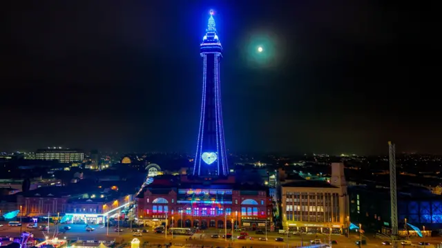 Blackpool Tower lit up in blue with a blue heart at night