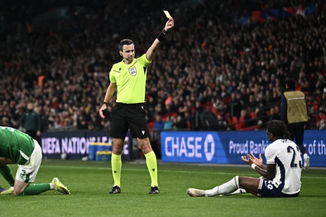 England's Noni Madueke is shown a yellow card by referee Erik Lambrechts