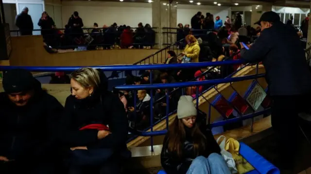 Inside a Kyiv metro station with people filling the stairs and waiting areas