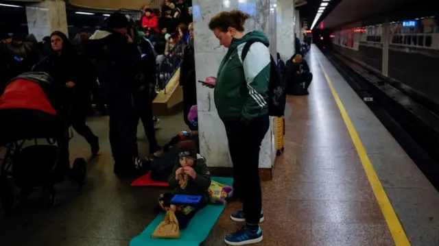 People, including a young child, seek shelter in a Kyiv metro station