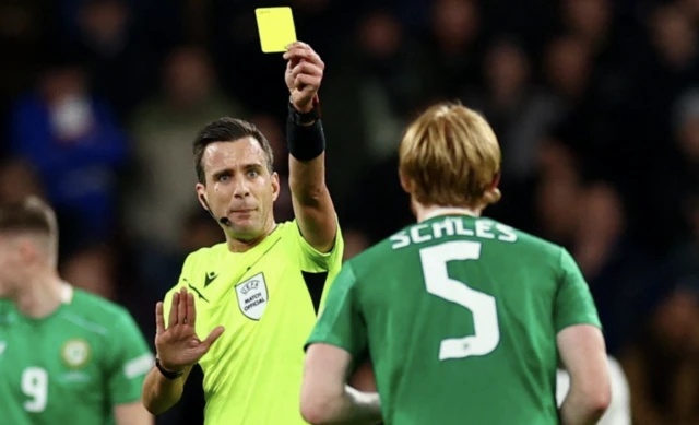 Republic of Ireland's Liam Scales is shown a yellow card by referee Erik Lambrechts