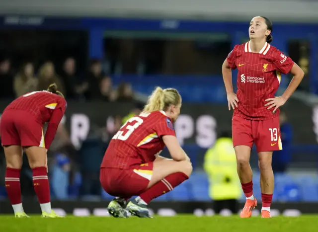 Liverpool players sink to the floor after the full time whistle