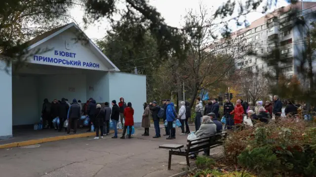 Around two dozen people queuing up for water