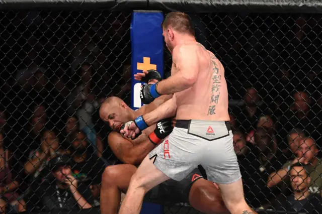 Stipe Miocic throws a punch at Daniel Cormier