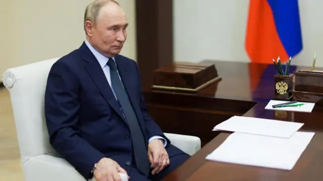 Vladimir Putin seated in an office