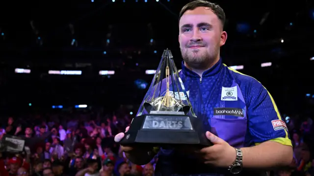 Luke Littler holds the Premier League Darts trophy