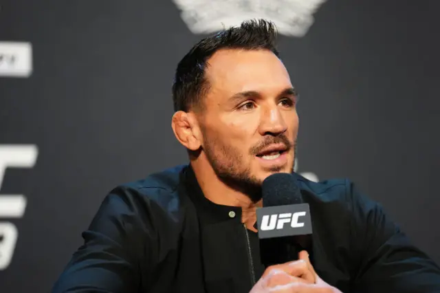 Michael Chandler speaks into a microphone