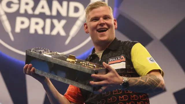 Mike de Decker holds the World Grand Prix trophy