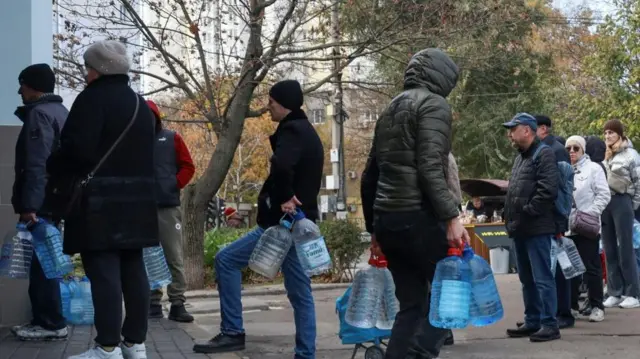 People queue up to fill plastic bottles with drinking water in Odesa