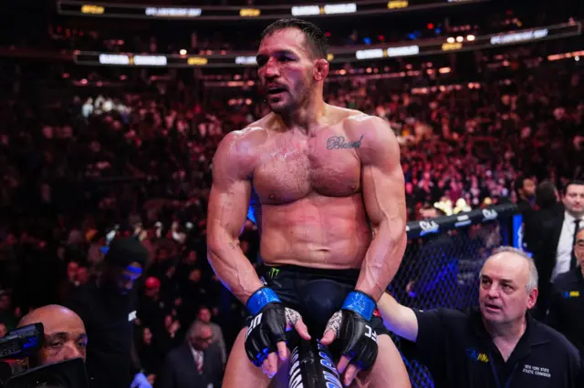 An exhausted Michael Chandler sits on top of the octagon