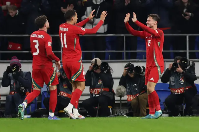 Neco Williams (L), Brennan Johnson and Liam Cullen (R) of Wales celebrate