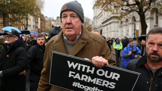 Jeremy Clarkson holds up a sign in Westminster that says 'With our Farmers'