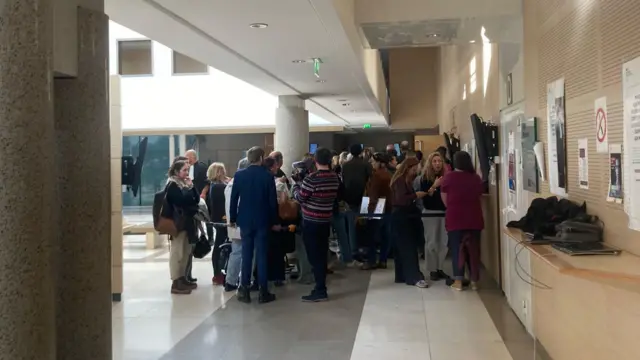 People huddle outside courtroom