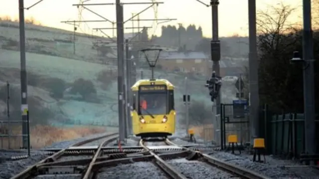 Mertolink tram in Greater Manchester showing frost on the hills in the backround and on the railway line