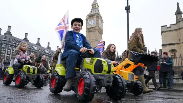 Children on toy tractors during a farmers protest