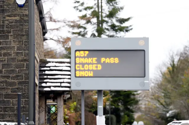 A sign saying "A57 Snake Pass closed snow"