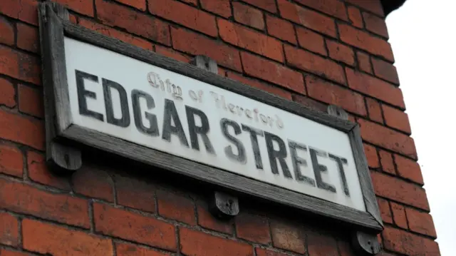 A white sign on a red brick wall reading Edgar Street in black lettering