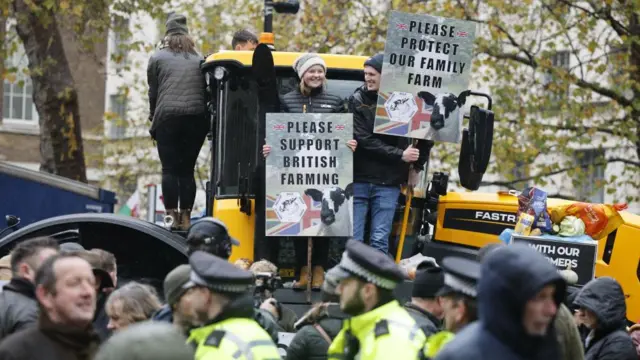 Protesters stand on a tractor during a protest in Westminster