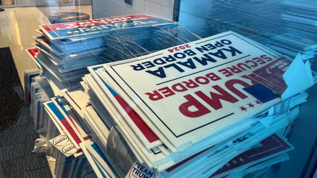 Signs with Donald Trump's name are seen stacked up in piles