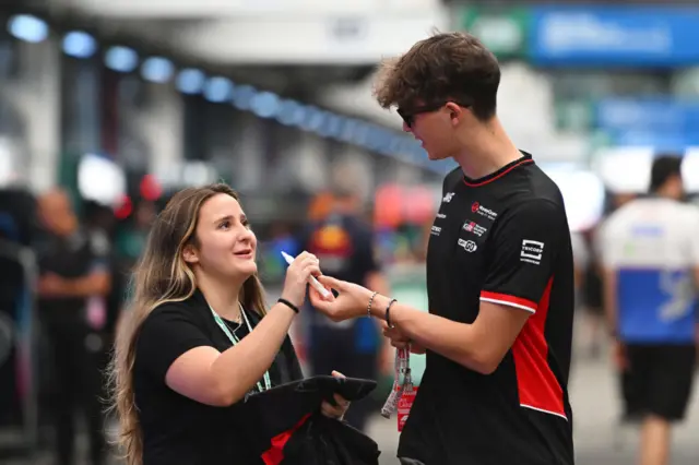 Ollie Bearman signs an autograph for a fan