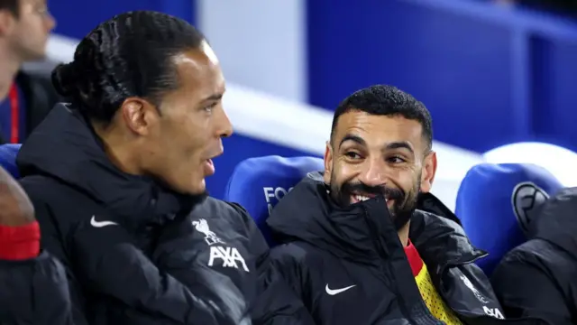 Mohamed Salah speaks to Virgil van Dijk of Liverpool on the bench during the Carabao Cup Fourth Round match between Brighton & Hove Albion and Liverpool