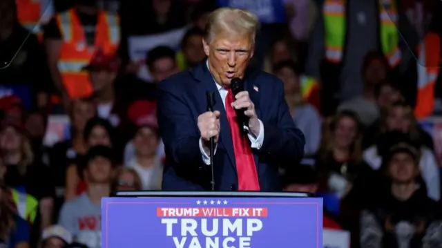 Donald Trump holding a mic at his rally in Wisconsin.