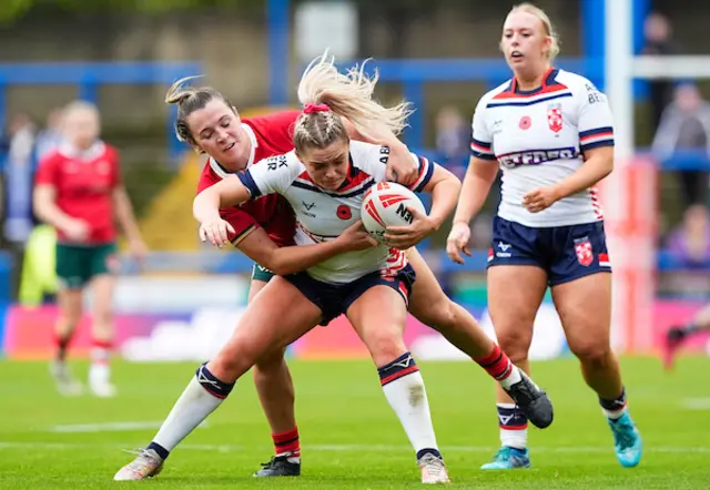 Eboni Partington of England is tackled by Georgia Taylor of Wales