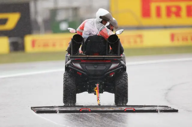 Intervention marshals check the track conditions after heavy rain fell at the Jose Carlos Pace racetrack