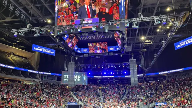 A stadium at a Trump rally is seen with bright blue lights