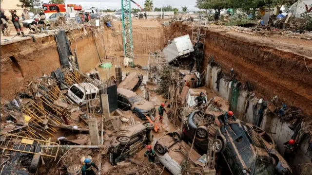 Civil Guard officers search for survivors inside cars trapped under the foundations of a building under construction