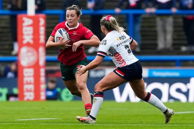 Georgia Taylor of Wales is tackled by Eboni Partington of England