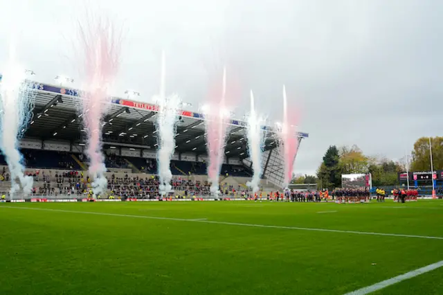 England and Wales squads line up whilst pyrotechnics go off in the background