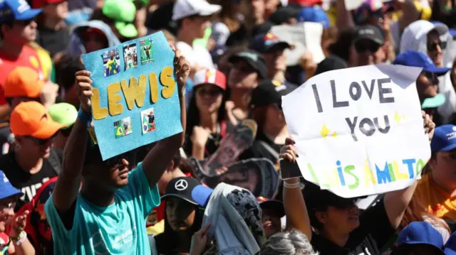 fans hold up signs for Lewis Hamilton