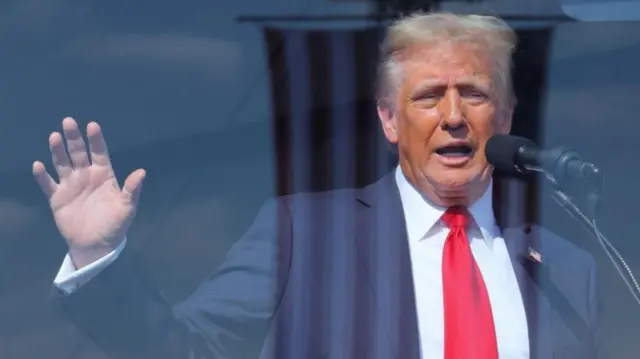 Republican presidential nominee and former U.S. President Donald Trump speaks during a campaign rally in Gastonia, North Carolina, U.S. November 2, 2024, behind a protective glass frame