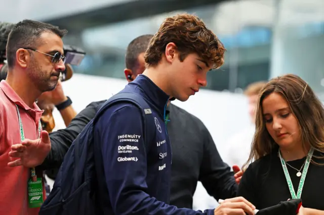 Franco Colapinto signs an autograph for a fan