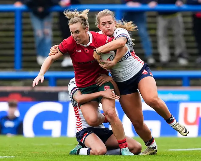 Bethan Dainton of Wales is tackled by Shona Hoyle of England