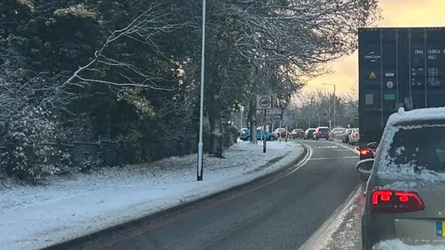 Queuing traffic on a road with snow on the sides of the road