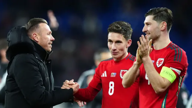 Wales coach Craig Bellamy shakes hands with Harry Wilson after the team's Nations League win over Iceland