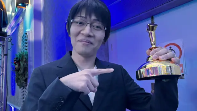 Naoki Hamaguchi holding the trophy