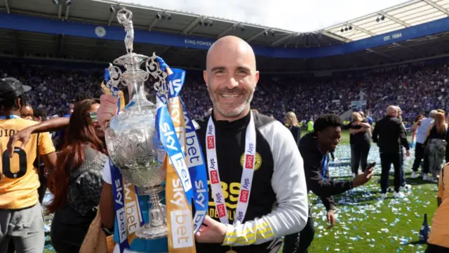 Enzo Maresca holds the Championship trophy at the King Power Stadium