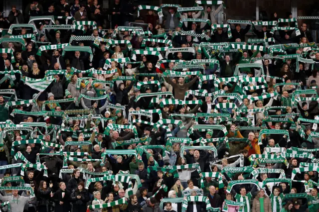 Fans of Hammarby show support for their team by holding up scarfs