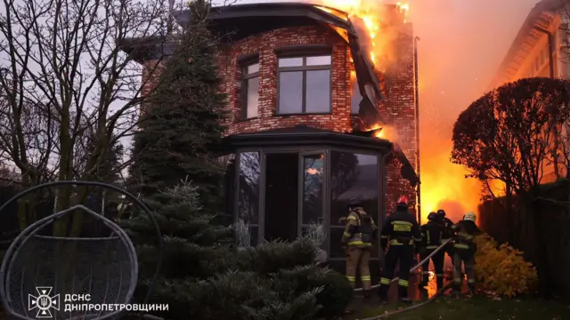 Firefighters battle a blaze at a residential building following a Russian missile attack.