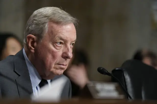 Headshot from side on of Dick Durbin who looks forward. The background is blurred